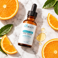 SkinBeauty Solutions Ferulic C&E Serum flat lay with orange slices